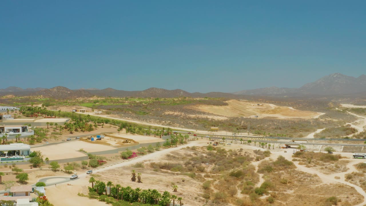 Desert roads and developed lots below a wide blue sky with mountains in the distance.