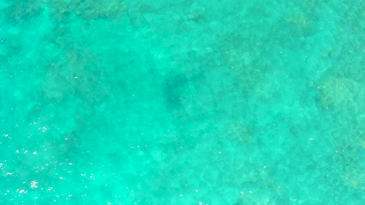 Clear turquoise water over mottled seabed
