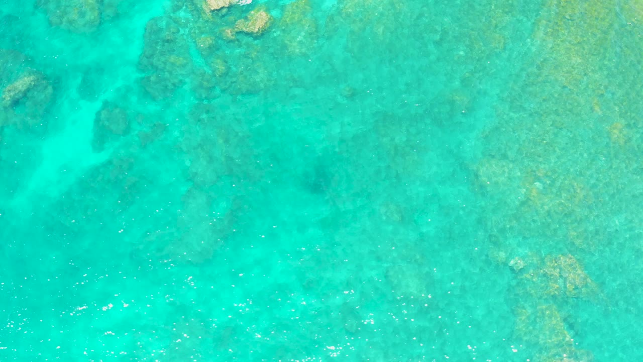 Aerial view of shallow reef under turquoise sea.
