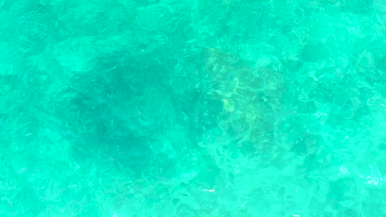Clear blue-green water with rocky bottom
