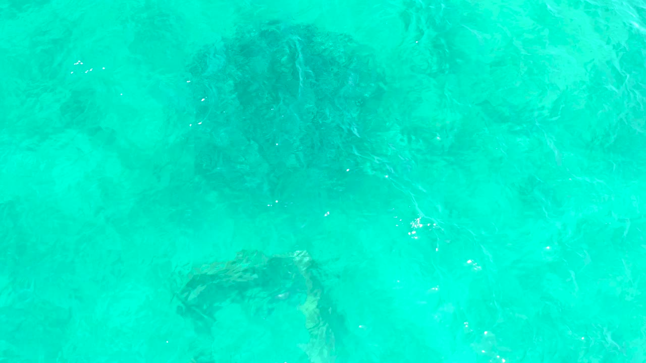 Pale turquoise water with darker underwater texture