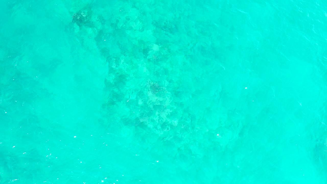 Turquoise water over submerged coral and rocks