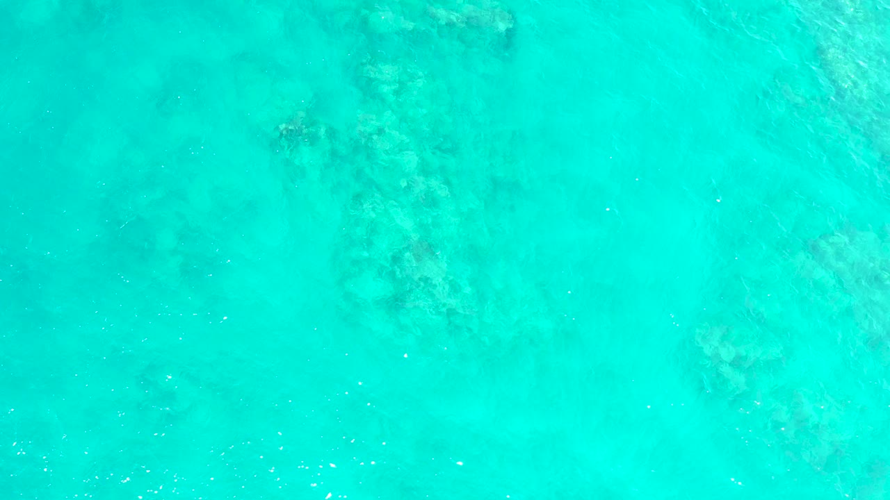 Turquoise shallow ocean water over a mottled seabed.