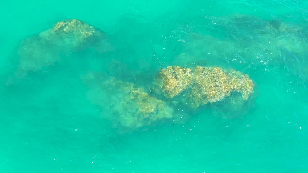 Shallow ocean water over clustered rocks