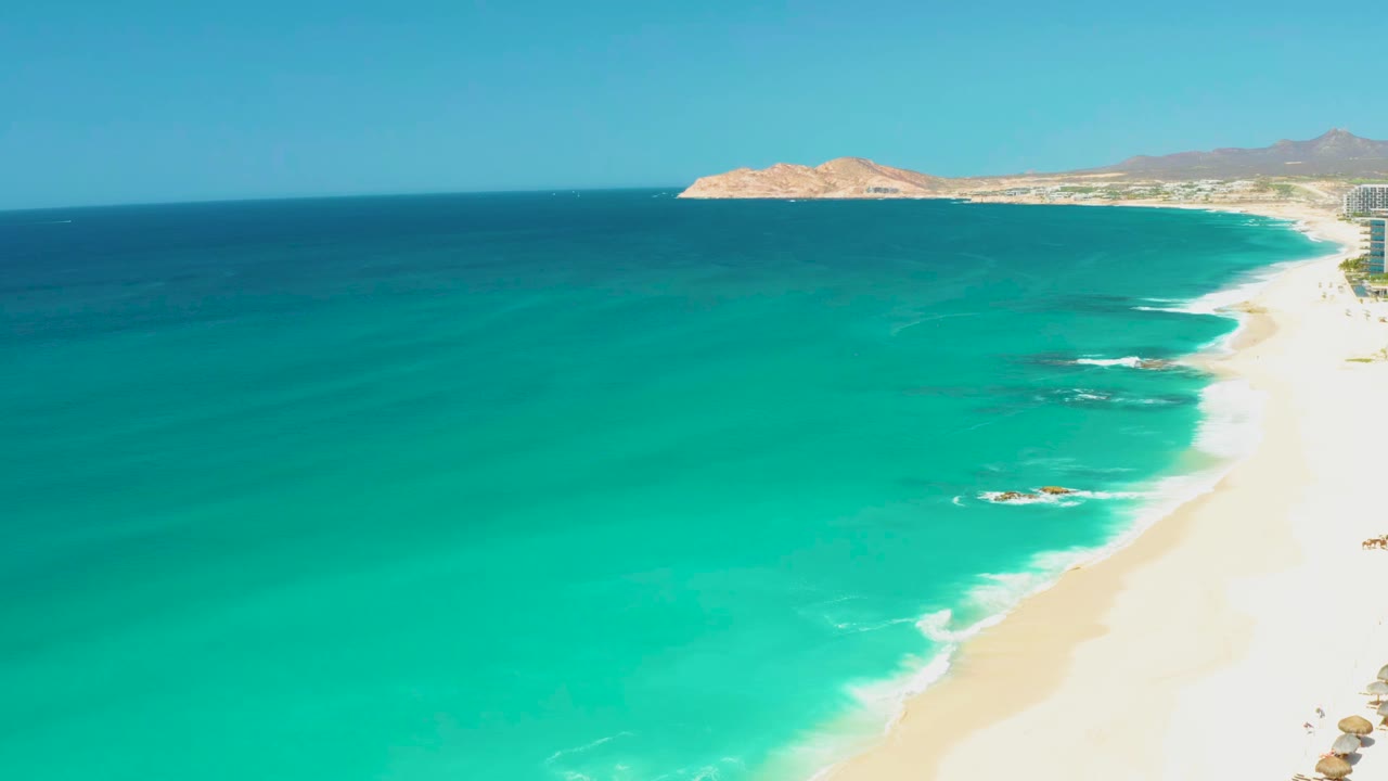 High aerial view of turquoise ocean beside a sandy beach