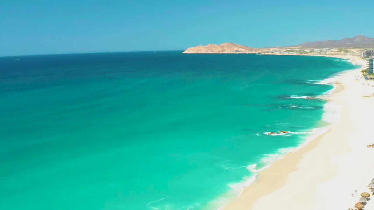 Second frame shows the same Dreams Los Cabos beach from above, with the surf line slightly farther down the sand and no visible people.