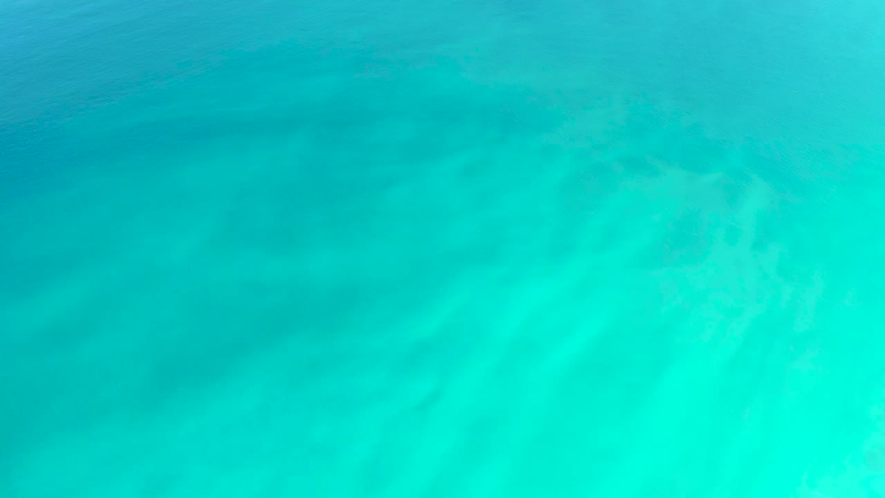 Turquoise ocean water over pale sandy seabed
