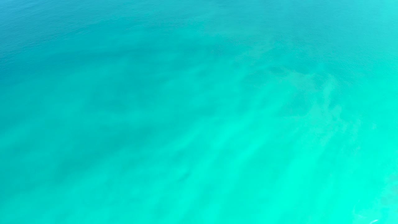 Transparent turquoise water fills the frame at Dreams Los Cabos, showing diffuse seabed texture and no visible people.