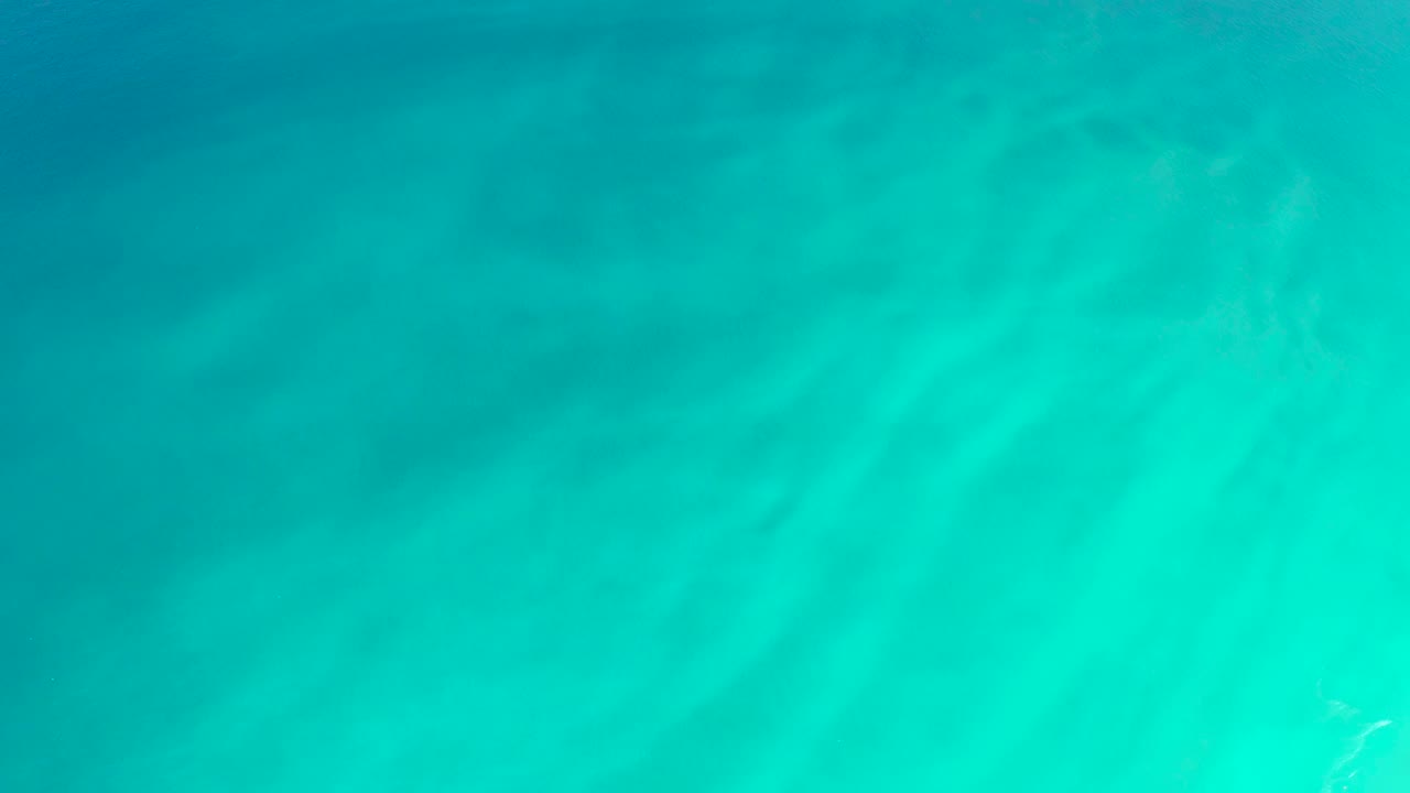 Turquoise water over a sandy ocean floor.