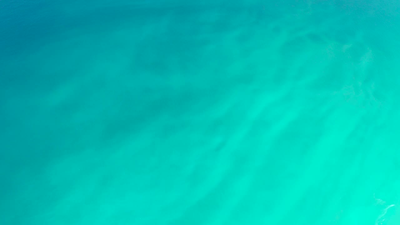 Clear turquoise water at Dreams Los Cabos shows rippled light across the sandy bottom, with no visible people or objects.