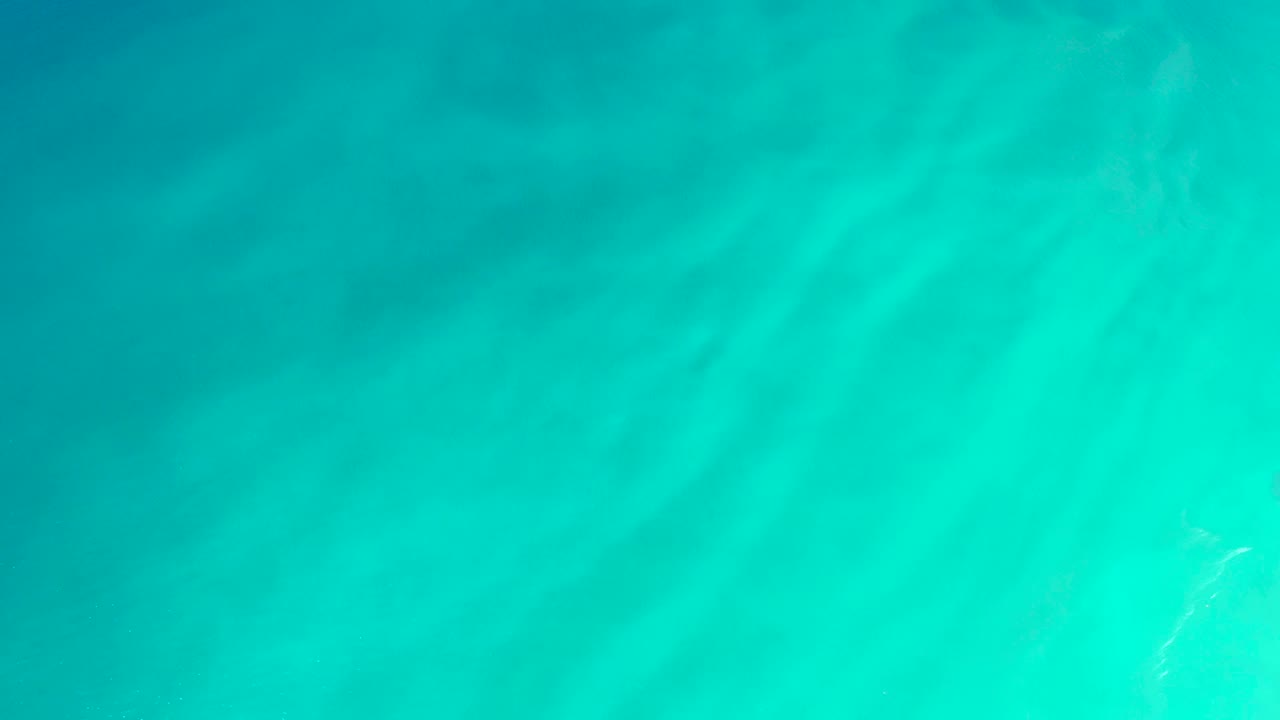 Clear blue-green ocean water at Dreams Los Cabos fills the frame with soft refracted light and no visible people.