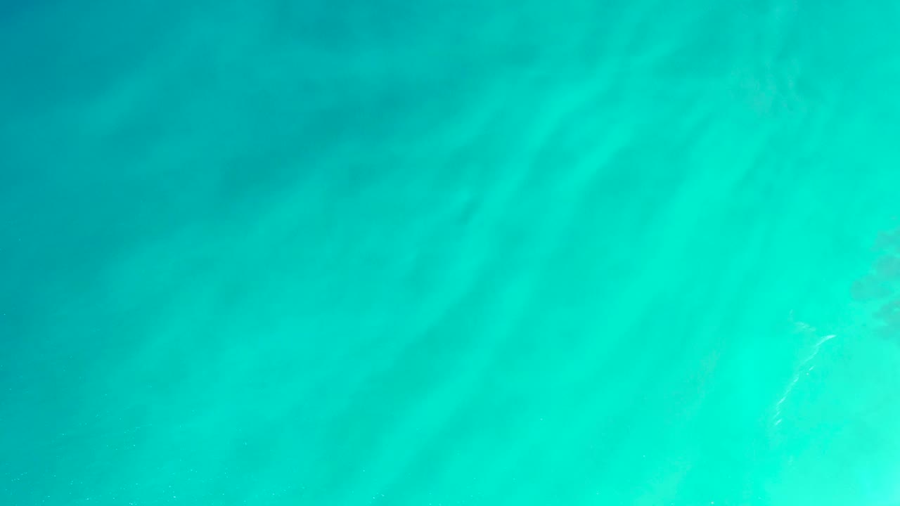 Turquoise water surface with darker underwater patch