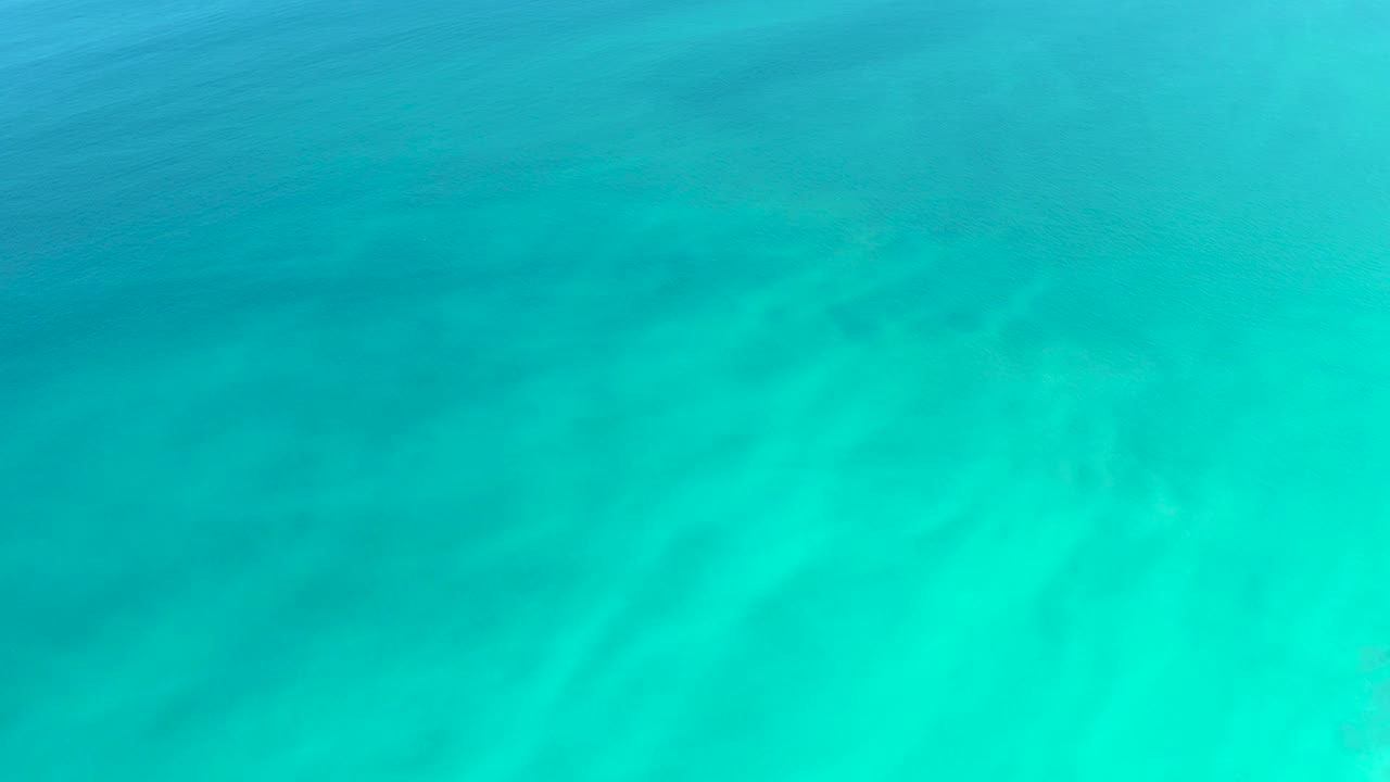 Transparent ocean water at Dreams Los Cabos reveals the sandy seabed beneath soft turquoise light refraction, with no visible people.