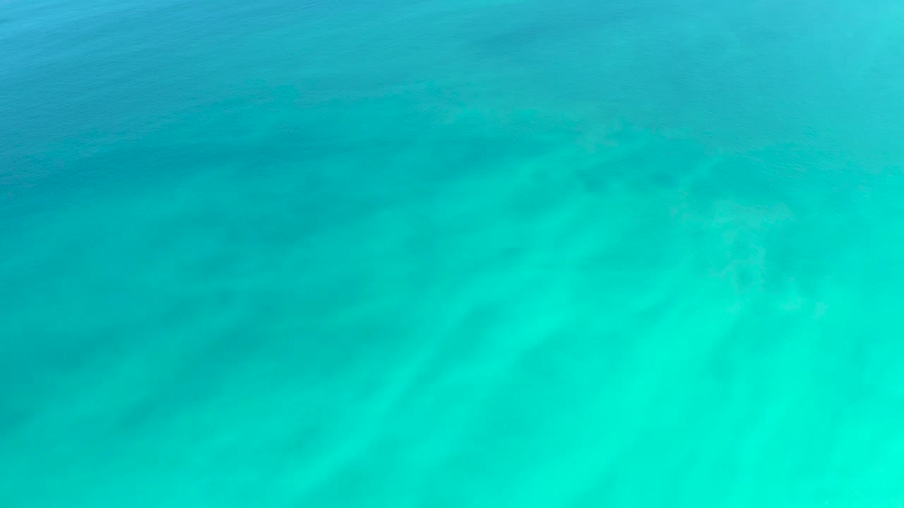 Turquoise shallow ocean water over a sandy bottom.