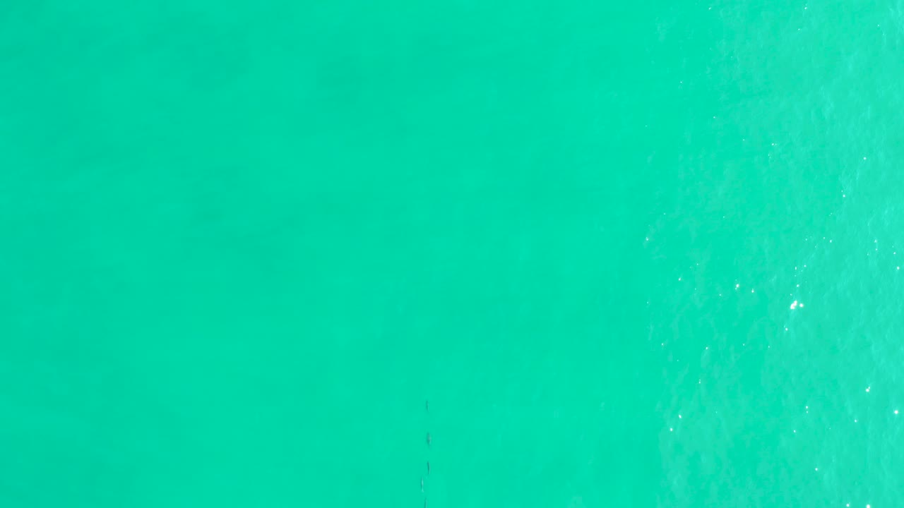 Overhead turquoise ocean surface in Los Frailes, Baja California Sur, with faint ripples, small sunlight flecks, and no visible people.