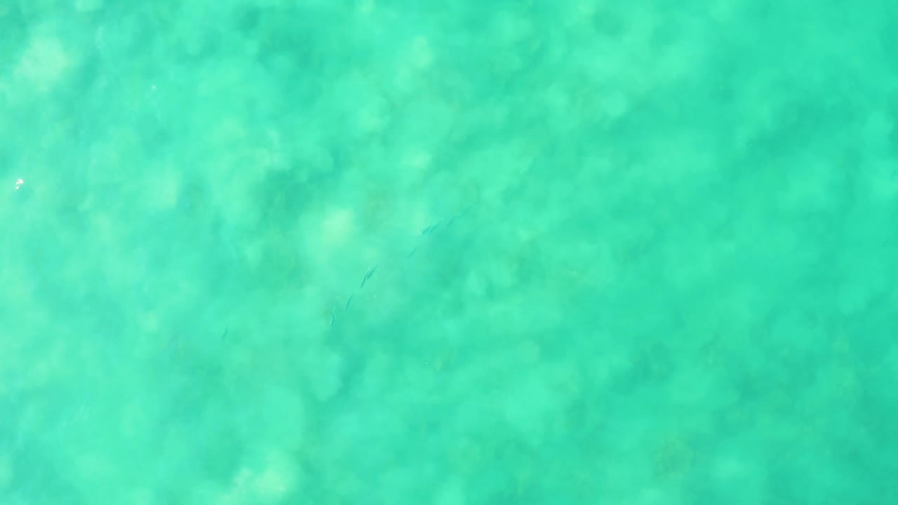 Turquoise ocean water with faint underwater formations.