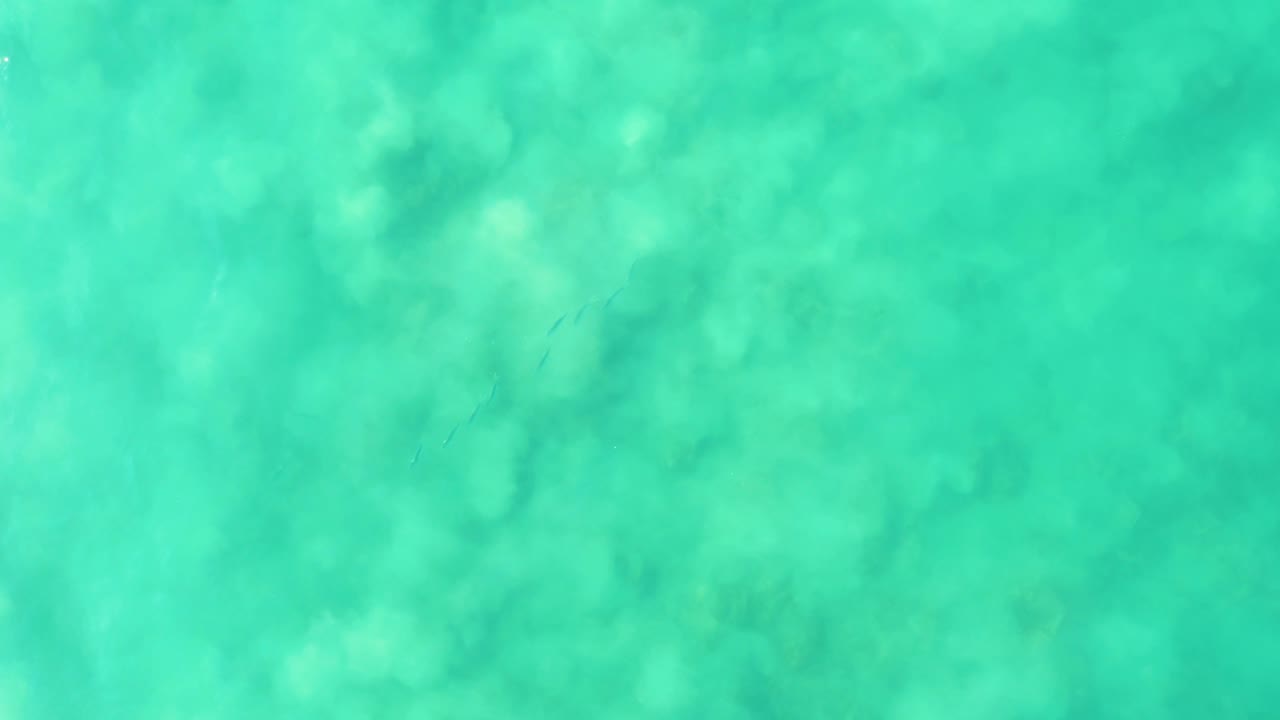 Transparent turquoise ocean water at Los Frailes with darker submerged coral or rock forms visible beneath the rippled surface and no visible people.