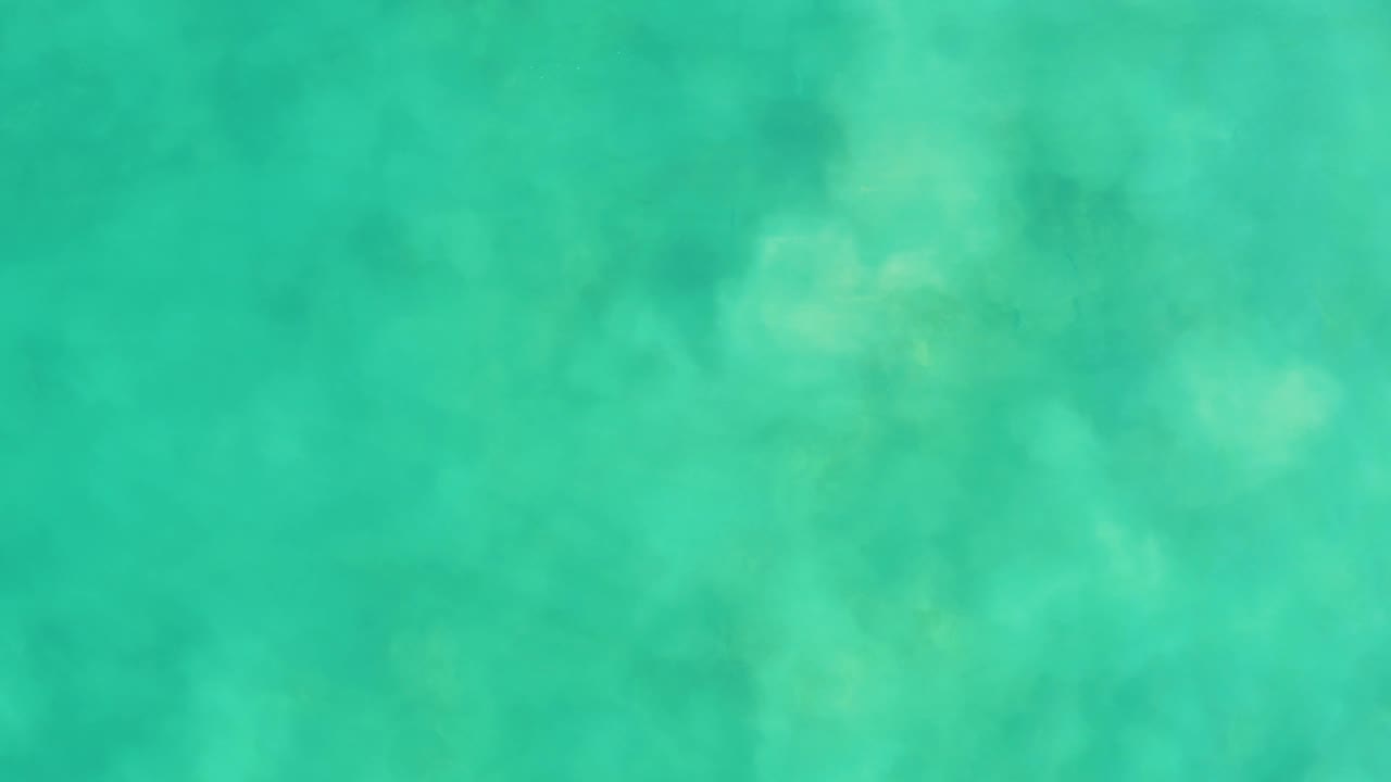 A shallow turquoise ocean frame from Los Frailes shows mottled seabed features beneath gentle surface movement and no visible people.