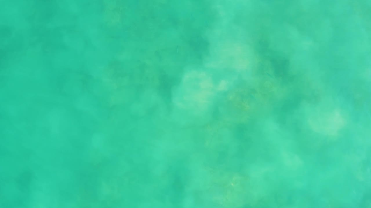Turquoise water with brighter light patches over the seabed.
