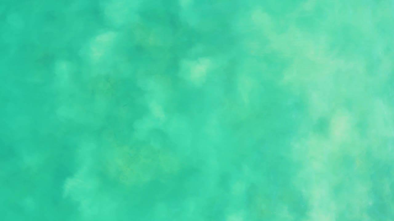 Overhead turquoise ocean water at Los Frailes, Baja California Sur, with faint pale patches below the surface and no visible people.