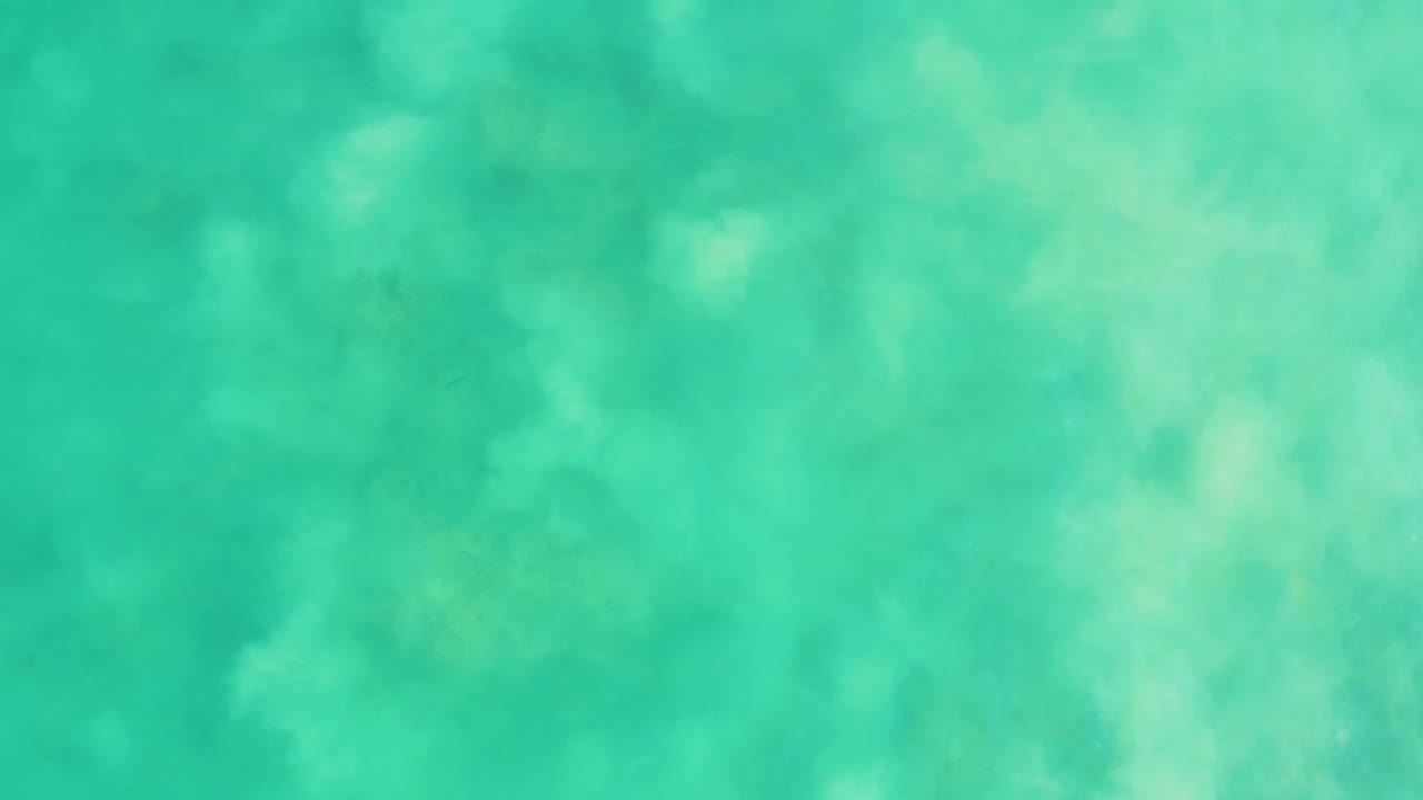 Clear green-blue ocean surface with soft ripples.