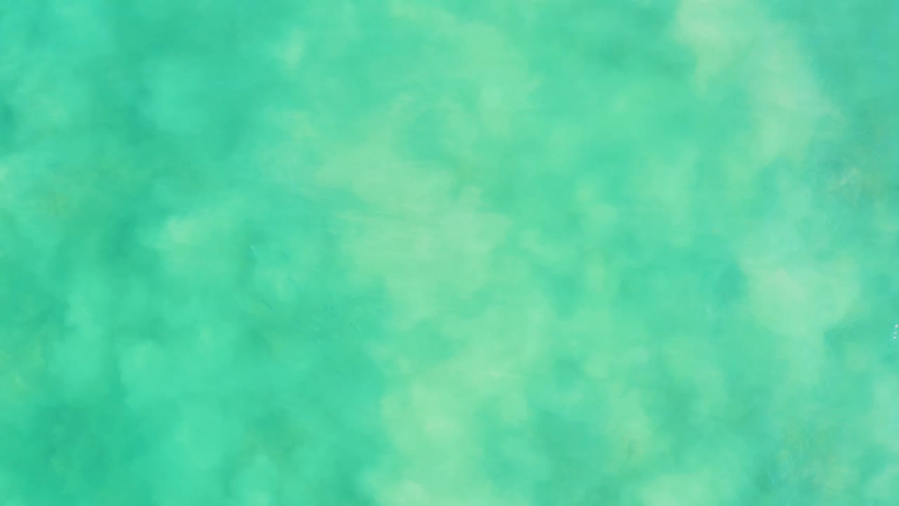 Green-blue water with soft cloudy seabed patterns.