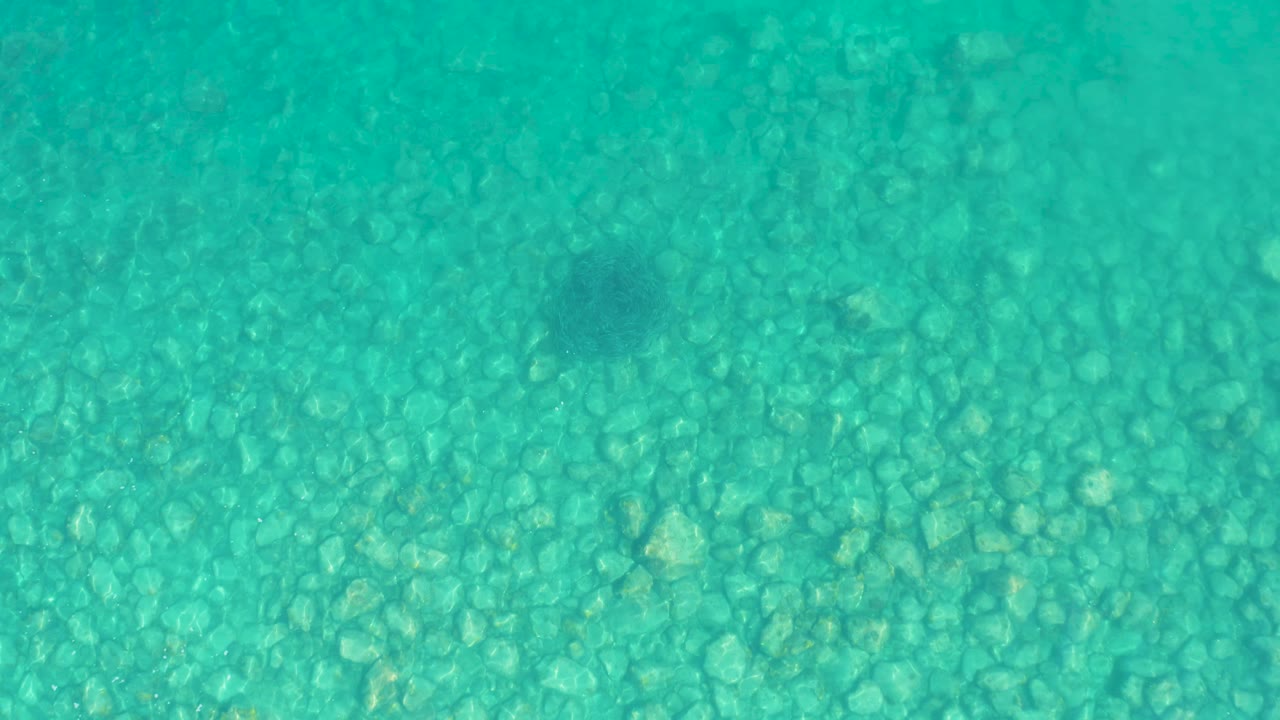 Turquoise shallow water over a pebbled seabed