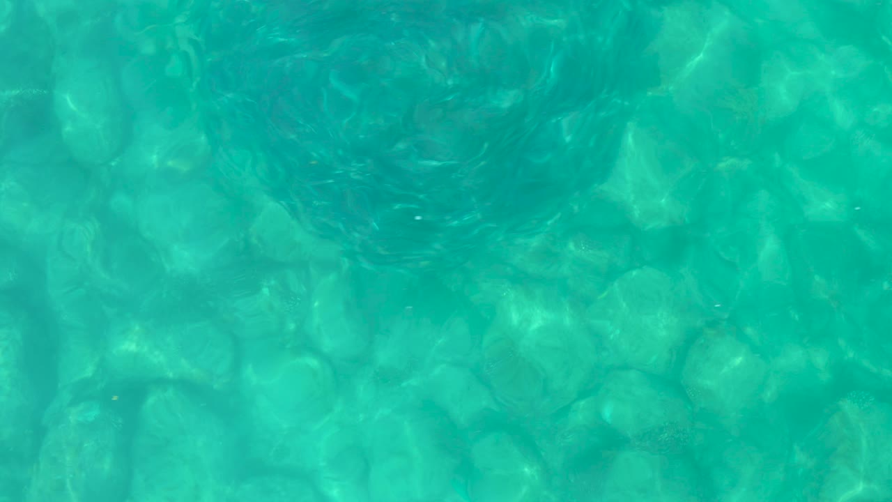 Turquoise pool water in Baja California Sur with wavering reflection patterns over the pool floor and no visible people.
