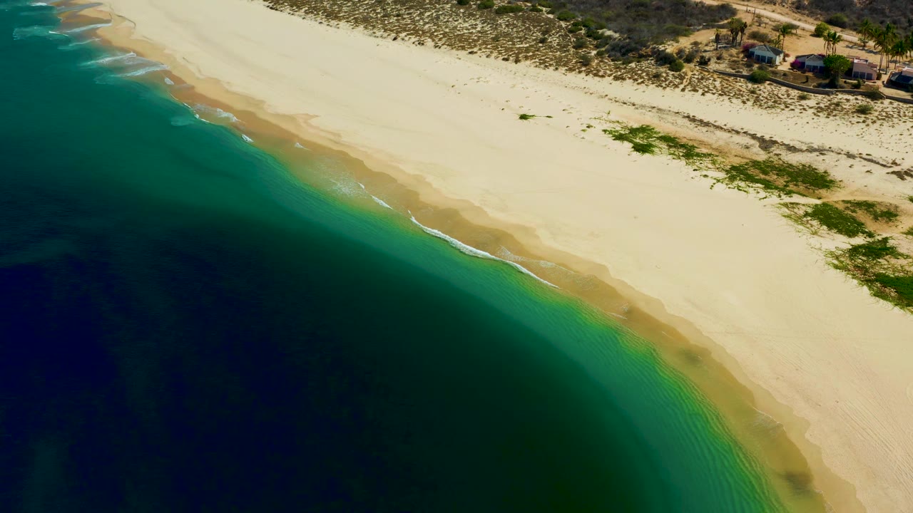 Diagonal aerial beach view with ocean filling the lower left