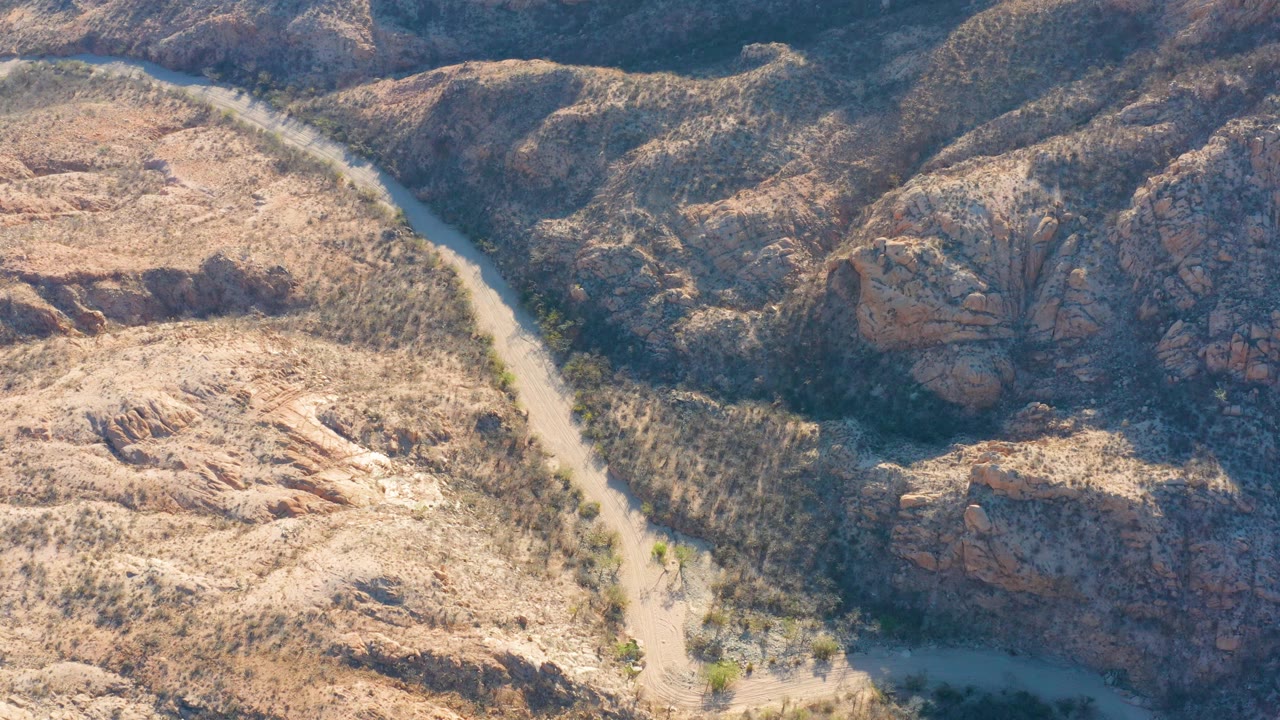 Aerial view of a winding river through dry rocky terrain