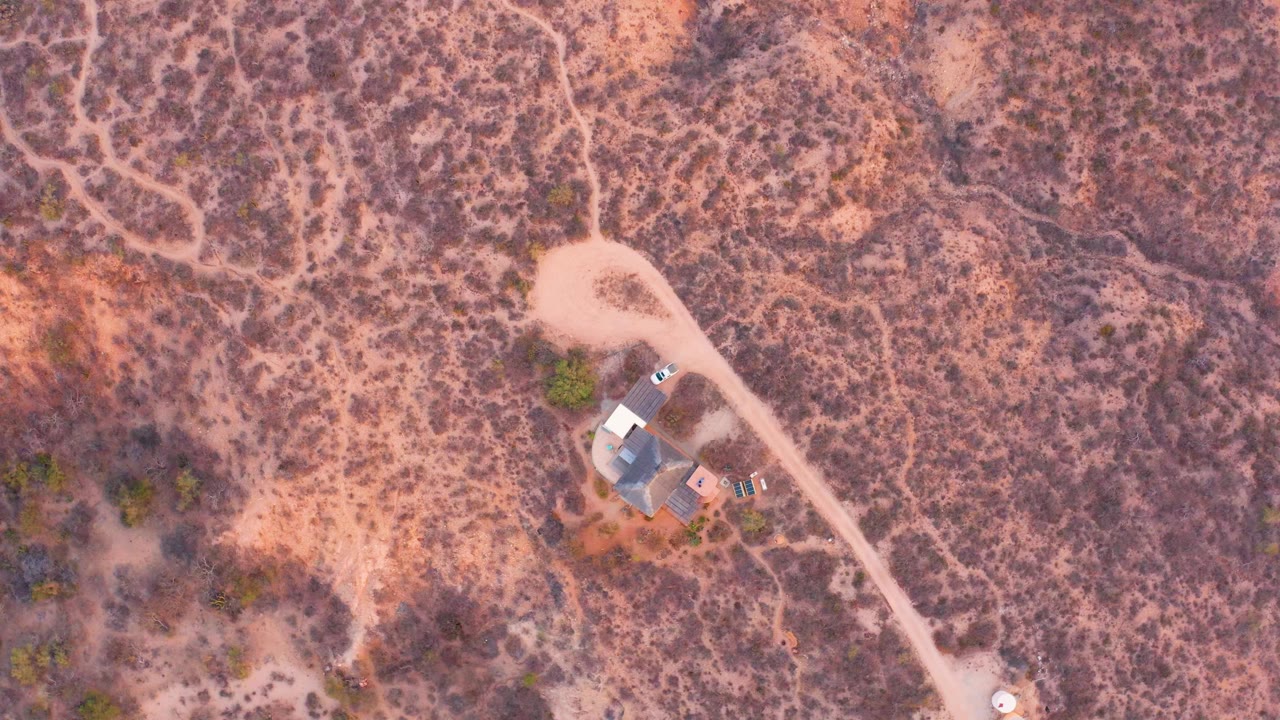 Aerial view of desert clearing and small house