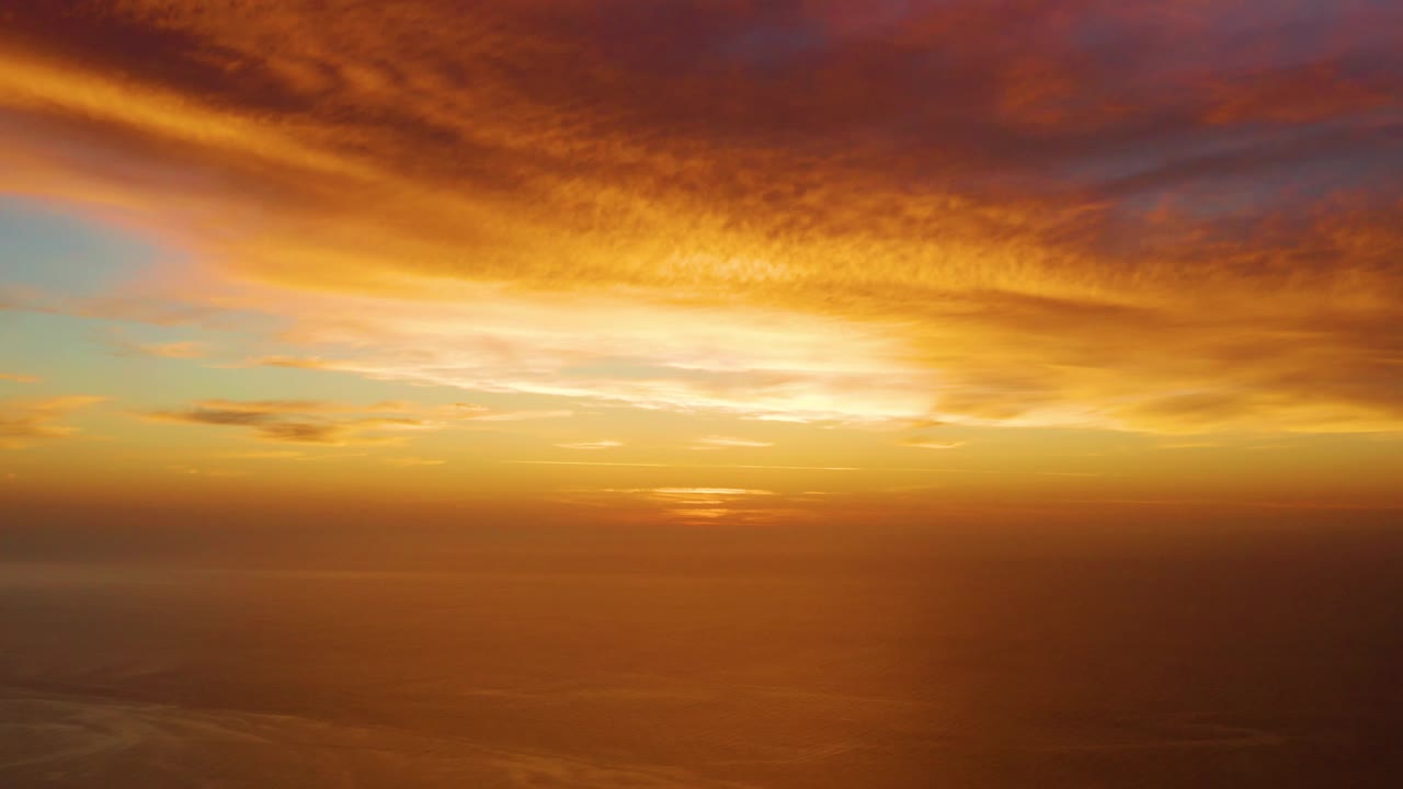 Opening frame of a golden sunset over the calm ocean in Cabo Pulmo, Baja California Sur, with orange cloud bands and no visible people.