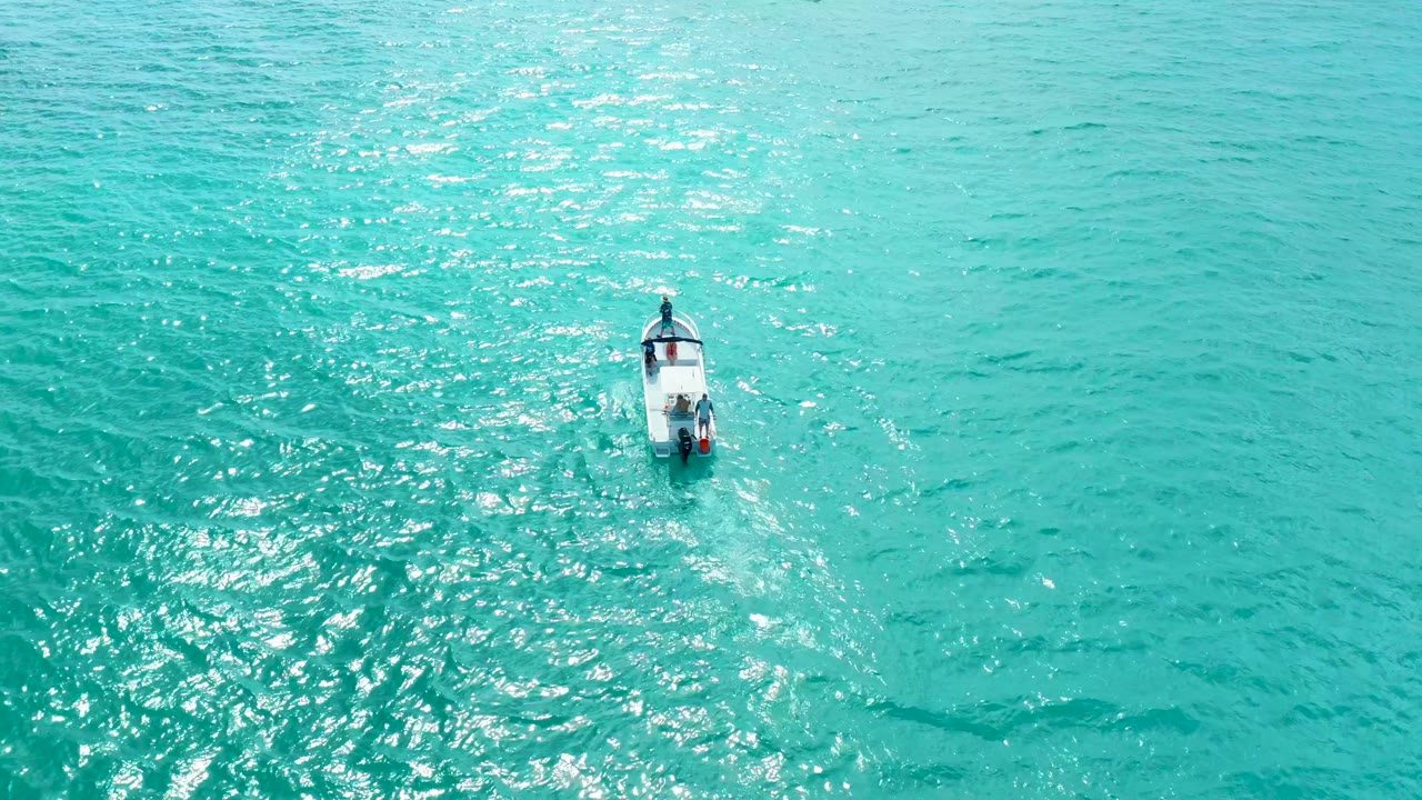 The small boat advances through open turquoise ocean in the Marquis Los Cabos clip, with textured ripples around the hull and no visible people.