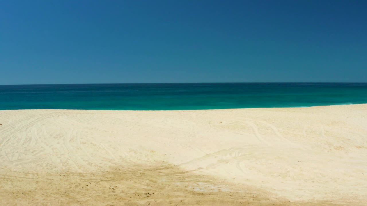 A second frame holds the Dreams Los Cabos beach view, with textured sand in front, turquoise water near the shore, darker ocean beyond, and no visible people.