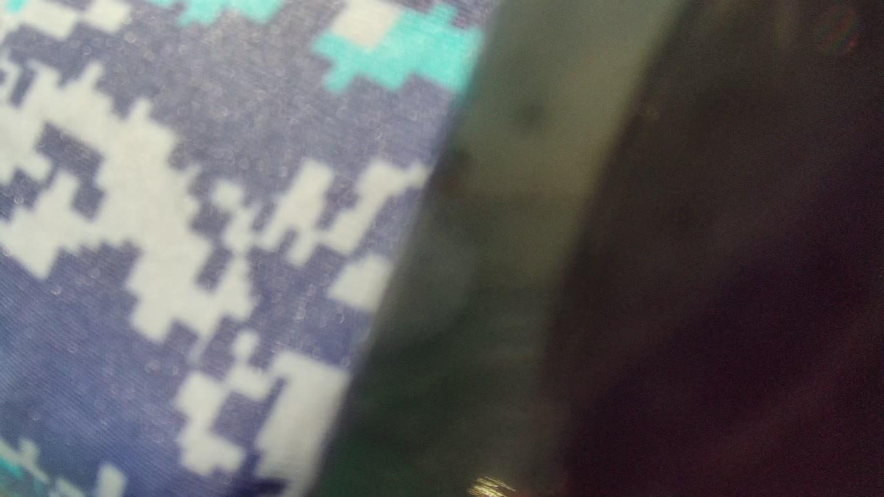 Blurred close view of camouflage rash guard and dark mask edge.