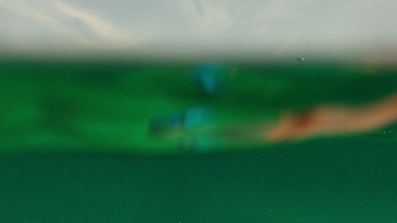 Soft, partially submerged green underwater view at Palmilla Los Cabos with blurred waterline and no visible people.