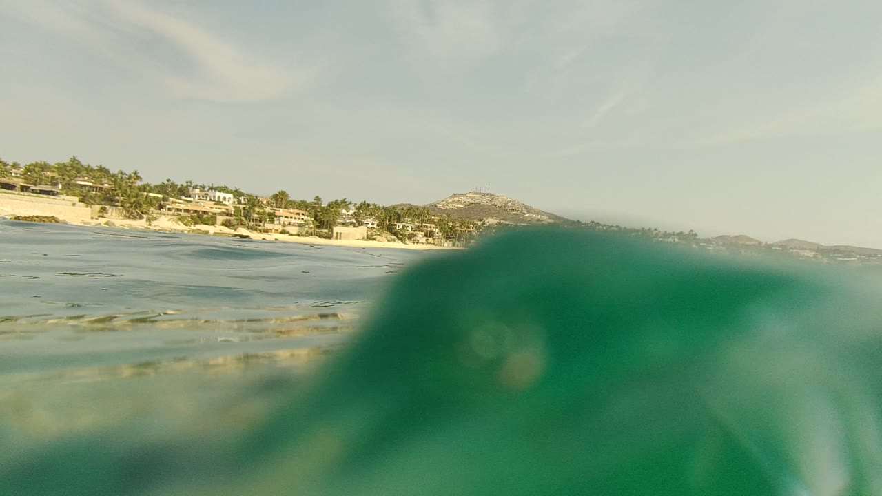 Low ocean surface with shoreline buildings and hills.