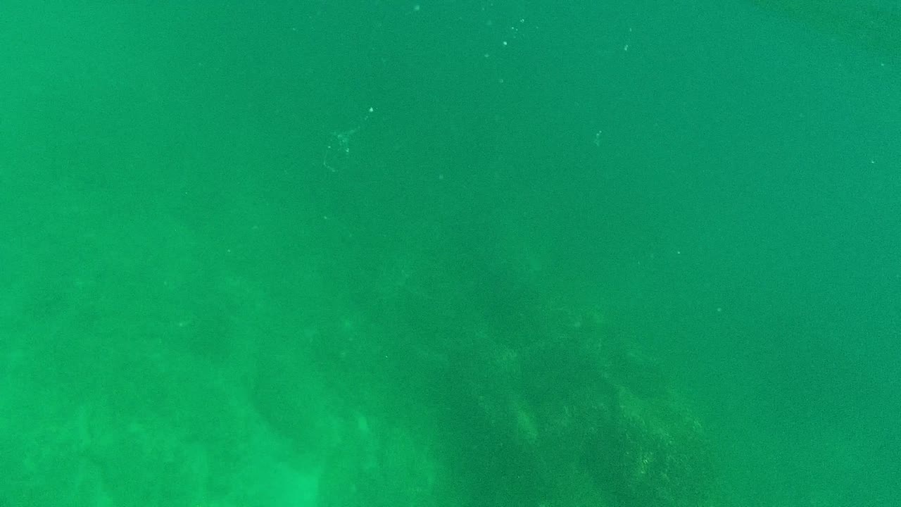 Underwater view with bright glare and faint seabed