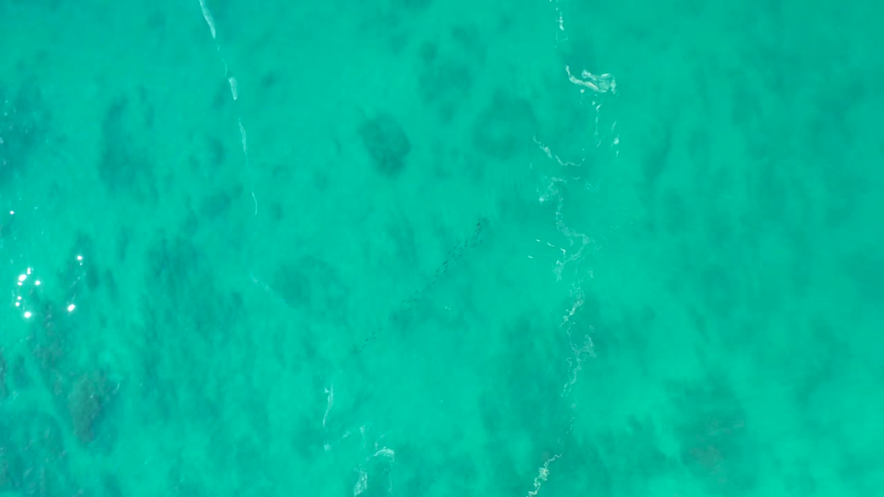 Clear aqua water with a narrow white ripple line
