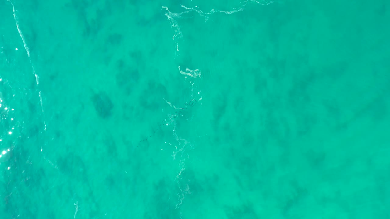 Aerial ocean surface with vertical white foam streak