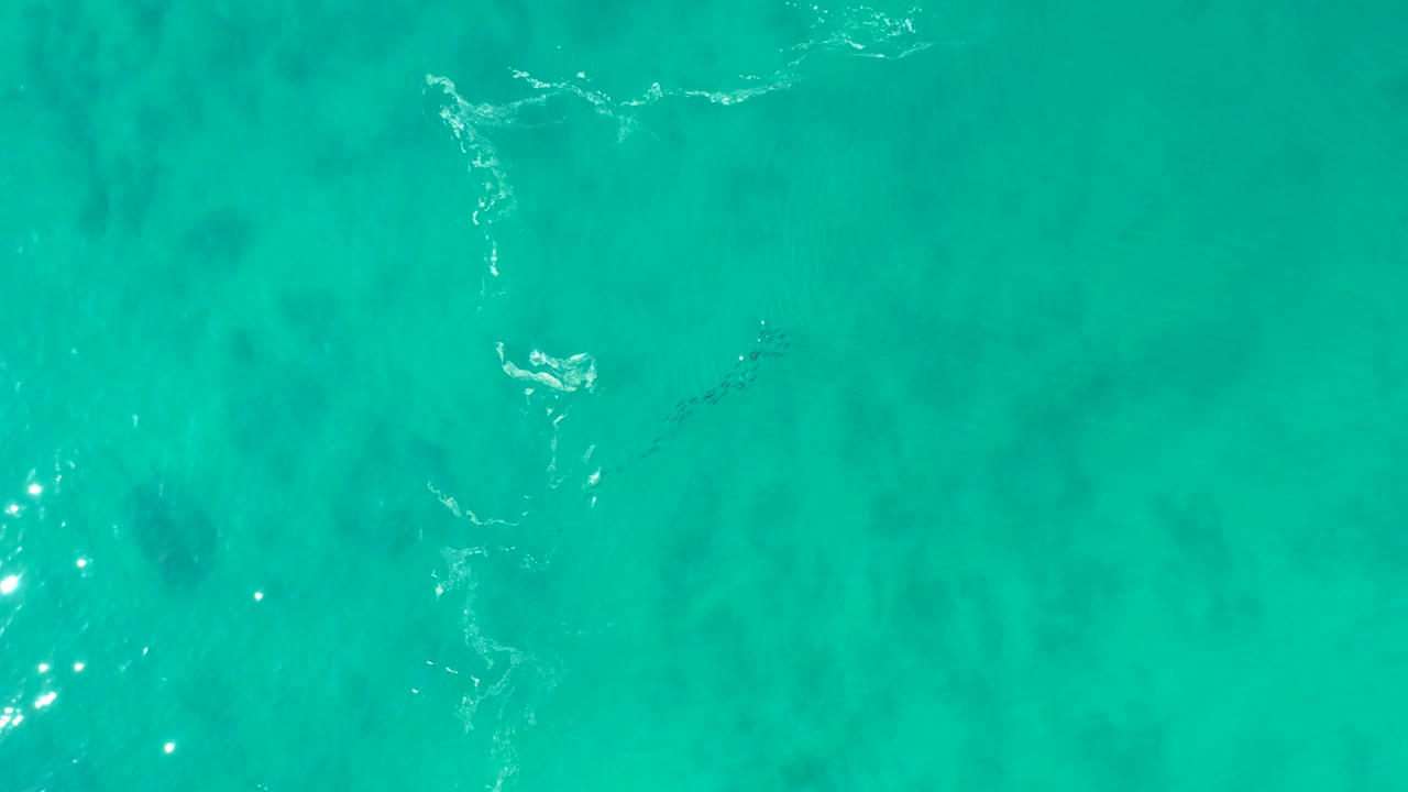 Turquoise shallow water with white foam streaks