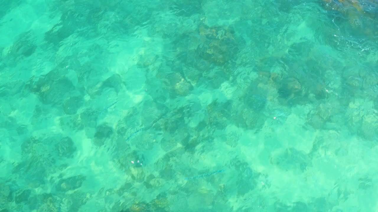 Marquis Los Cabos, Mexico, shallow ocean water with mixed rock shapes under shifting turquoise light and no visible people.