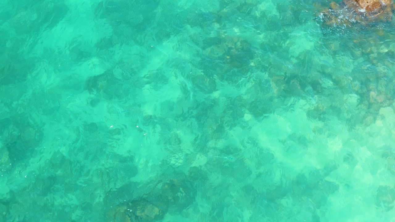 Clear turquoise water with rocks beneath the surface