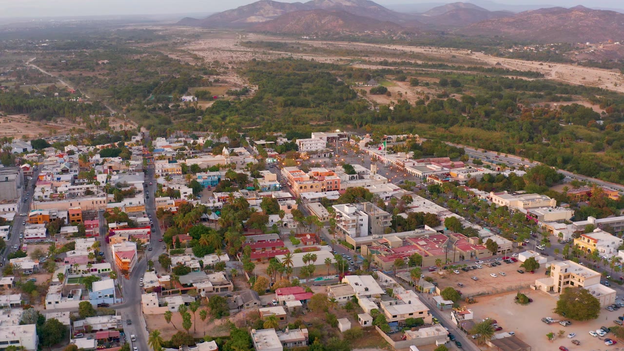 Aerial neighborhood blocks beside green vegetation and dry open land