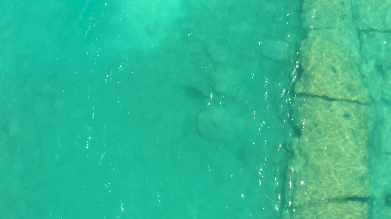Overhead turquoise water with submerged stone edging