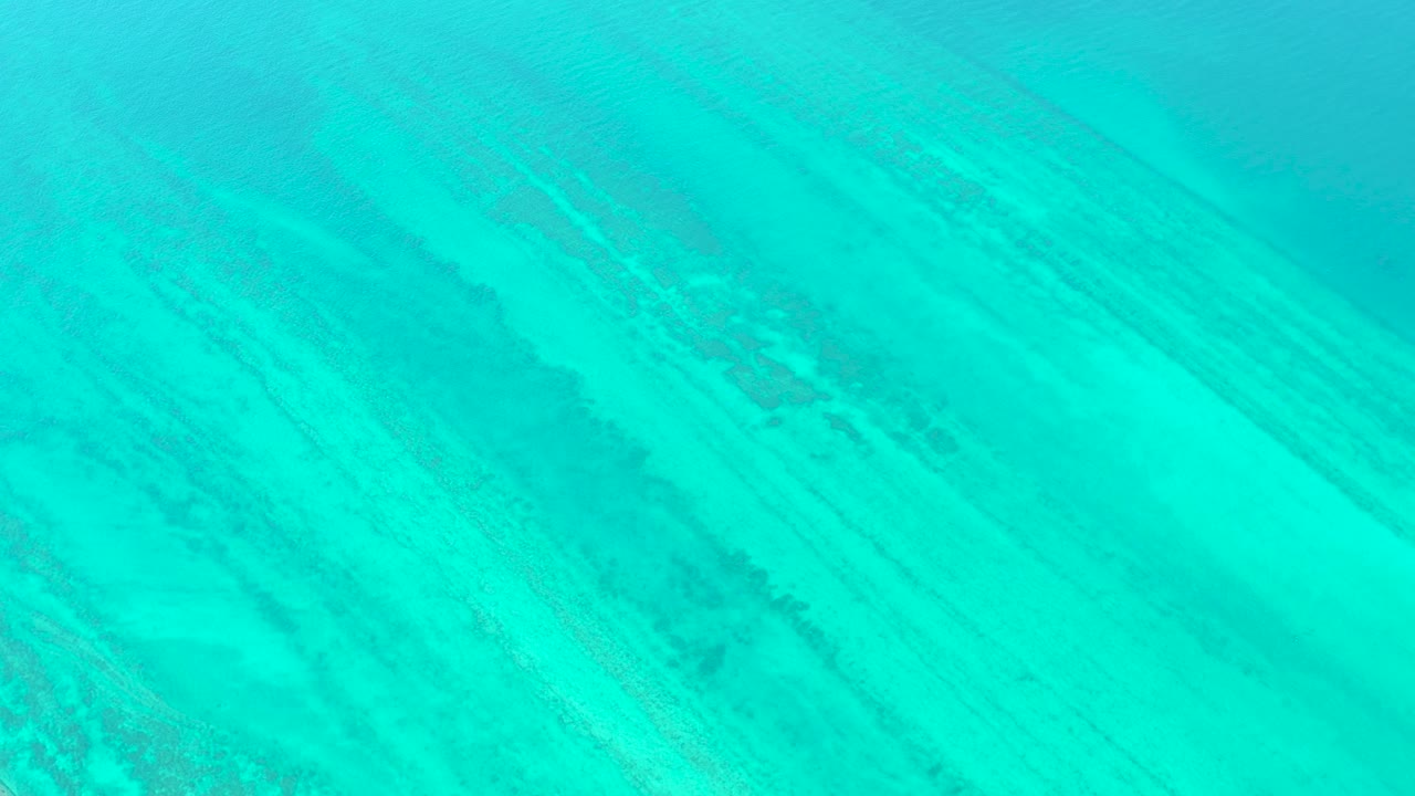 Diagonal underwater reef texture appears beneath smooth turquoise water in Cabo Pulmo, Mexico, with no visible people or marine life.