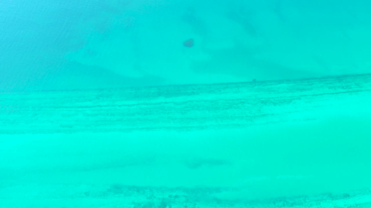 Third frame in Cabo Pulmo, Baja California Sur, showing shallow turquoise water with soft horizontal seabed shading and no visible people.