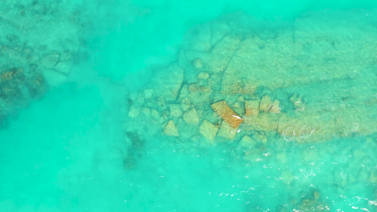 Turquoise sea over a pale rocky shelf