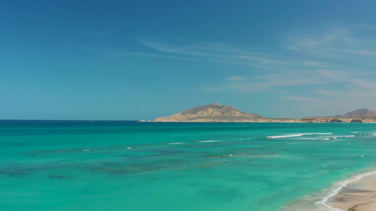 Cabo Pulmo turquoise water spreads across the frame as small whitecaps form near the right shoreline, with no visible people.