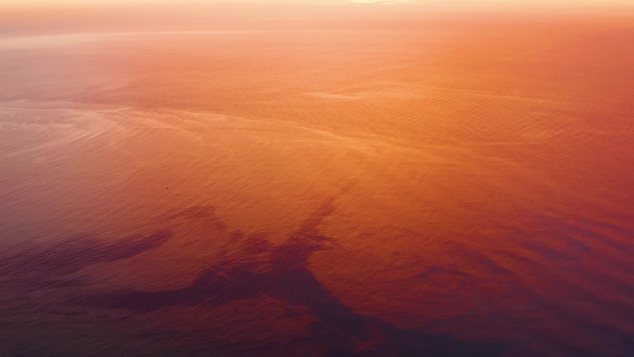 Golden orange water fills the frame in Cabo Pulmo, Baja California Sur, with small ripples, a pale highlight near the top, and no visible people.